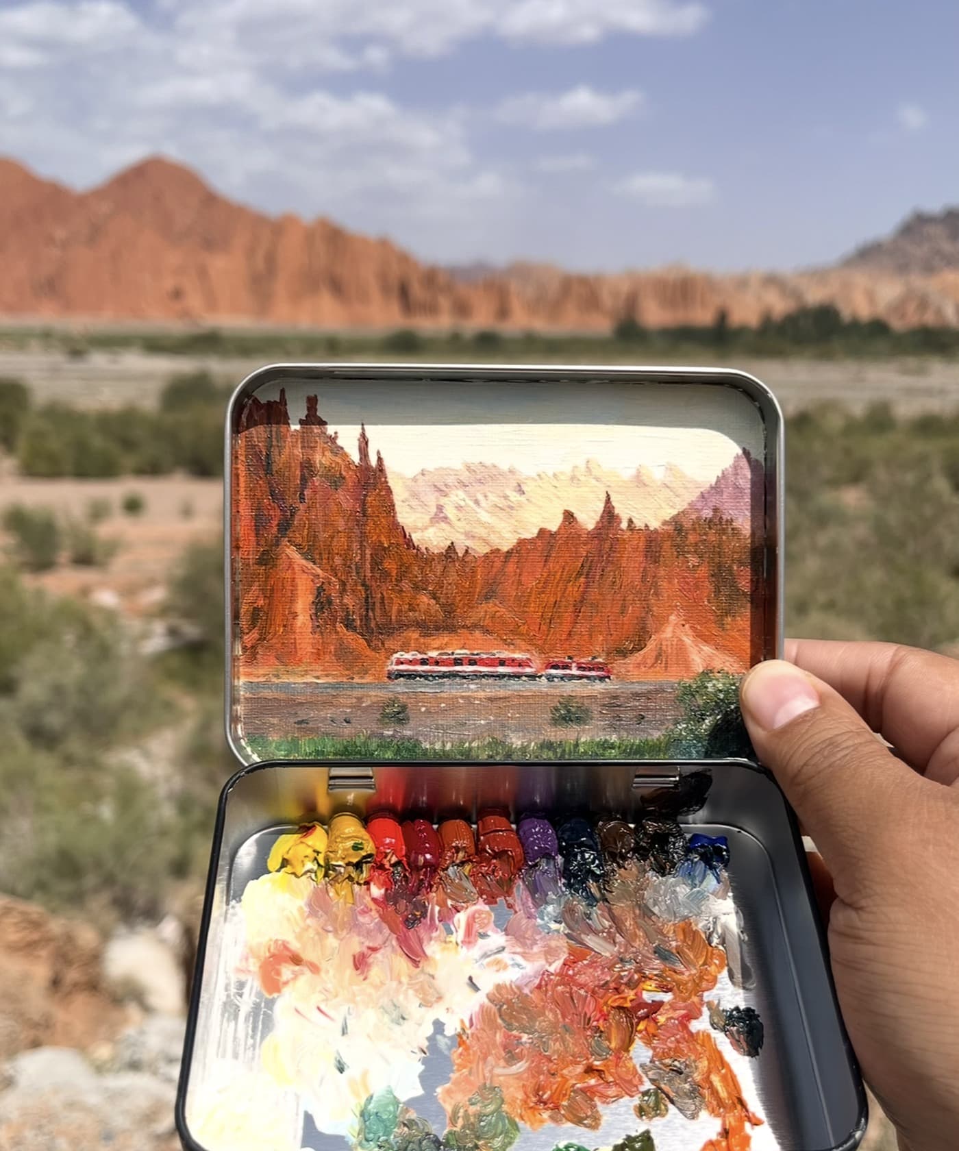 Finished red rock train pocket painting held in hand